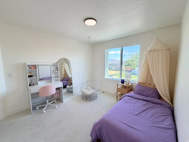 Recessed lighting, large window, and light-colored wall-to-wall carpeting
