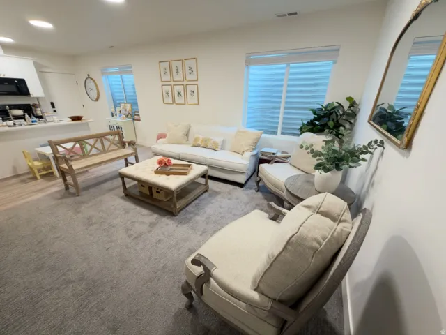 Recessed lighting, light-toned walls, gray carpeting, white window blinds, and white cabinetry