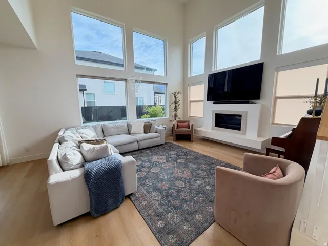 Vaulted ceilings, expansive windows, wood-finish flooring, built-in fireplace, and a large television mount