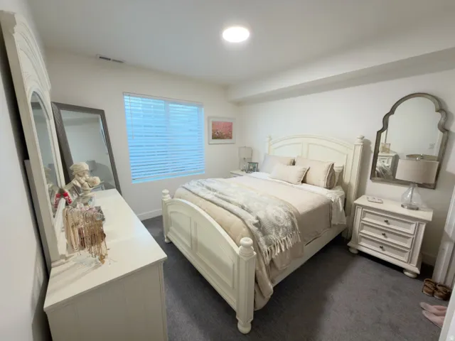 Recessed ceiling lighting, window with horizontal blinds, and dark gray carpeting