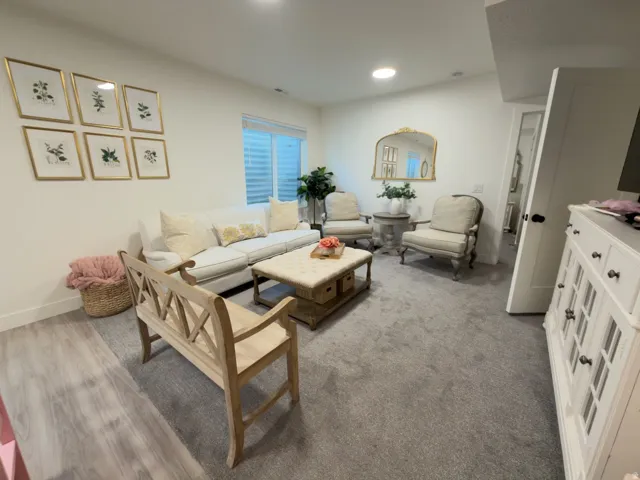 Recessed lighting, wood-finish flooring, and light-toned carpeting define this inviting space