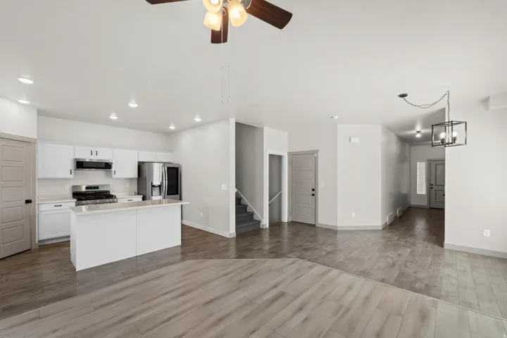 Open-concept living area featuring wood-finish flooring, recessed lighting, and a modern ceiling fan