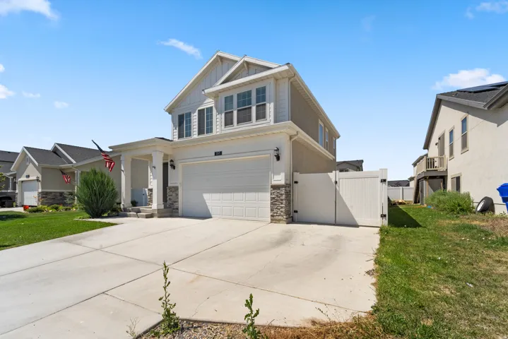 Two-story residence featuring a covered front porch, an attached two-car garage, and a concrete driveway