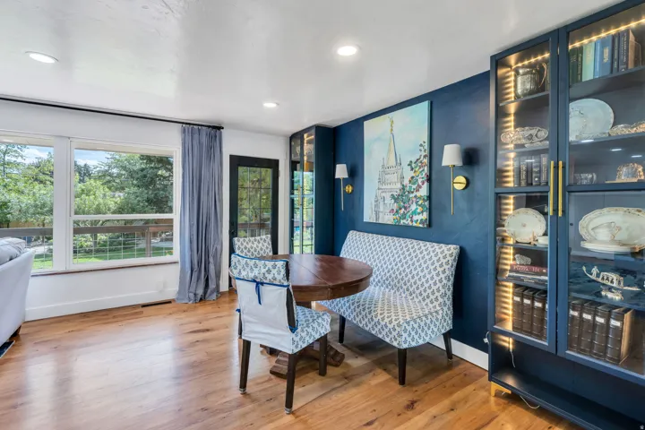 Hardwood flooring, recessed lighting, expansive windows, built-in display cabinetry with internal lighting, and a dark-toned accent wall