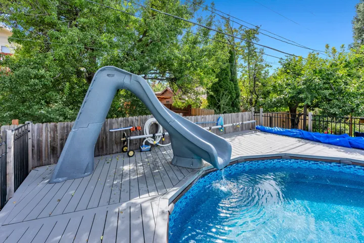 Pool deck with a built-in slide and a privacy fence