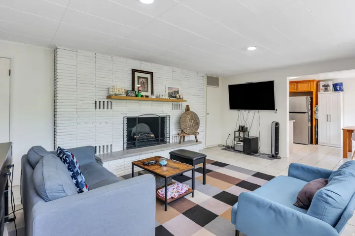 White brick fireplace with stone hearth and wood mantel