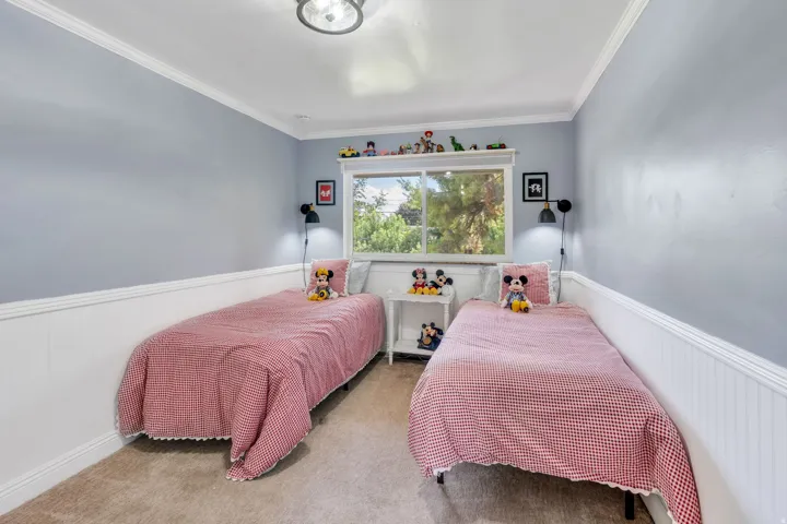 Wall-to-wall carpeting, window with a built-in display shelf, and crown molding