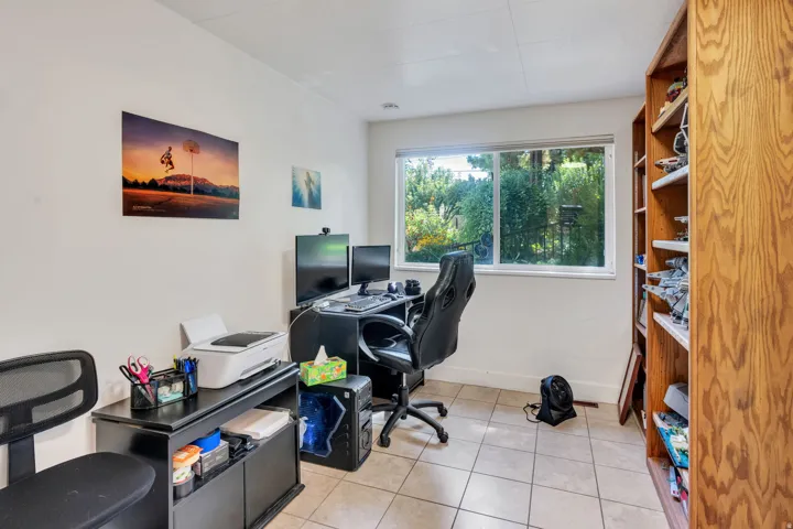 Large window, built-in wood-finish shelving, and tile flooring