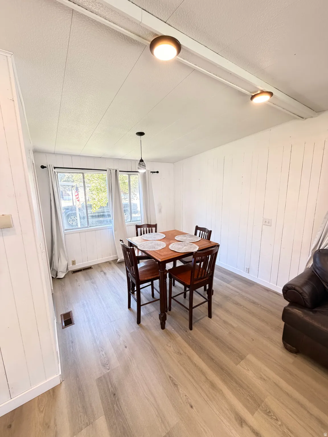 Wood-finish flooring throughout, complemented by white plank walls