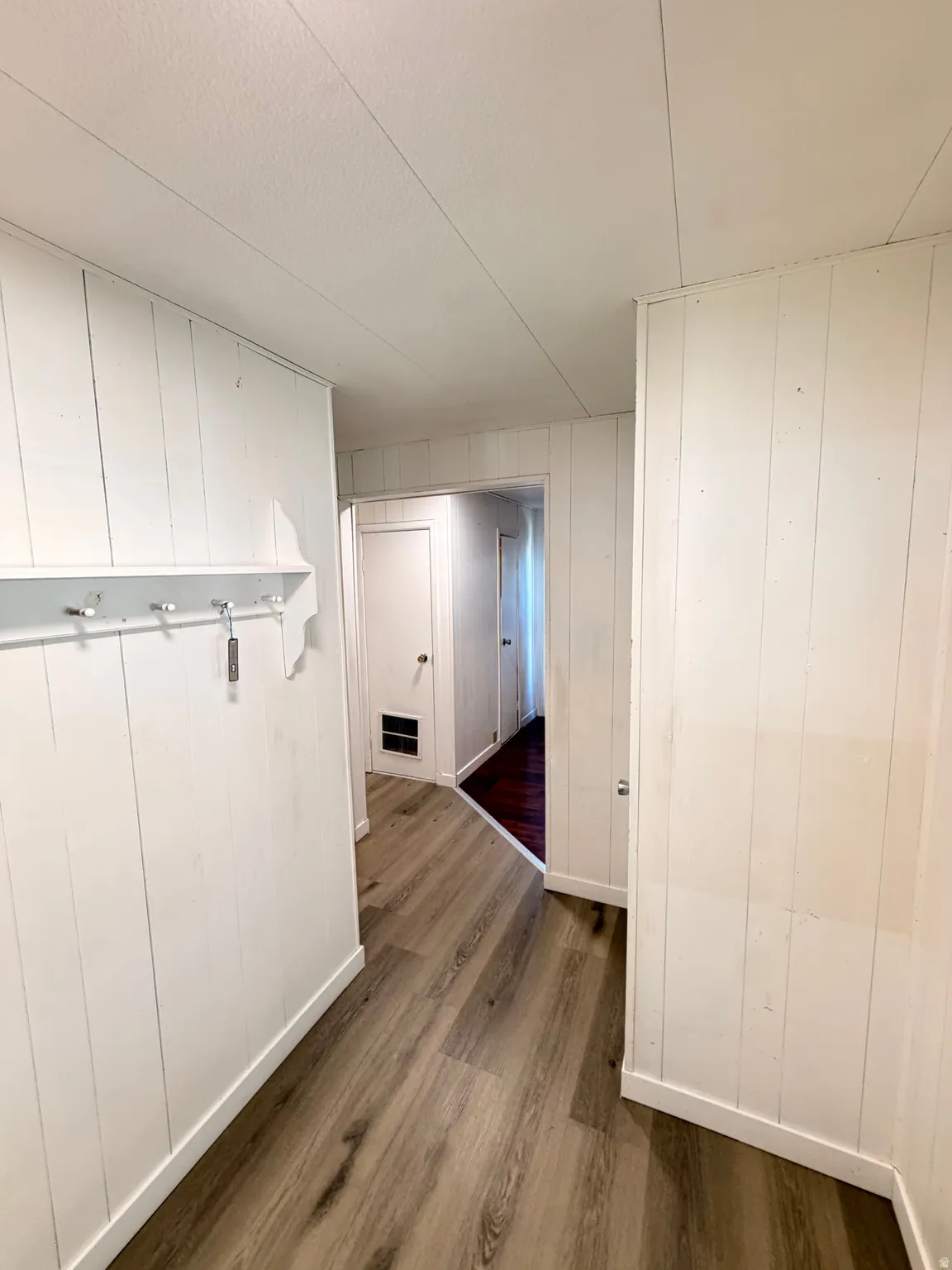 Wood-finish flooring, white paneled walls, white trim