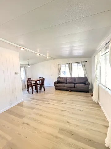 Wood-finish flooring throughout, white paneled walls, and multiple windows