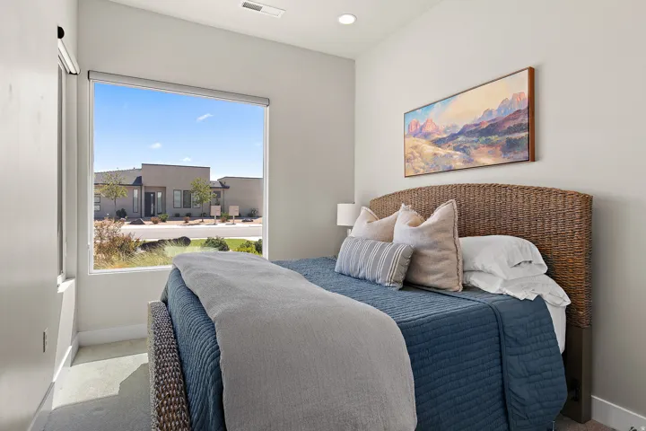 Expansive window, recessed ceiling lighting, light-toned wall paint, and carpet flooring