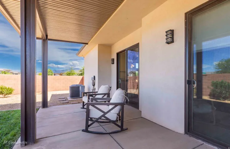 Covered patio featuring a corrugated metal roof, concrete flooring, and stucco exterior walls