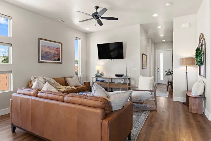 Open-concept living space with wood-finish flooring, recessed lighting, and a ceiling fan
