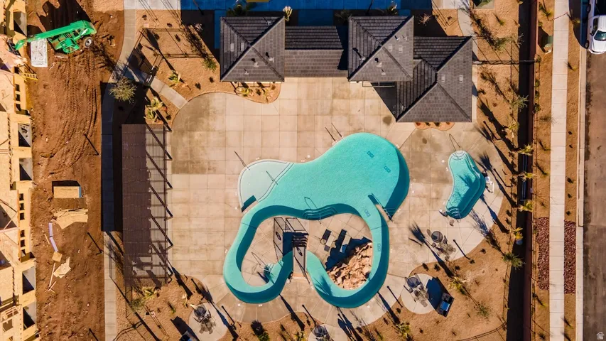 Two distinct swimming pools, extensive concrete decking, a covered pergola, and a multi-level building with dark roofing