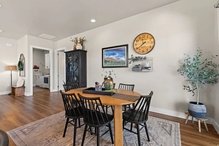 Wood-finish flooring throughout, recessed ceiling lighting, and a laundry area with built-in shelving