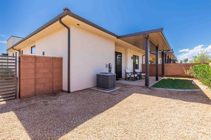 Rear exterior featuring a covered patio, gravel landscaping, and a fenced yard with a privacy wall