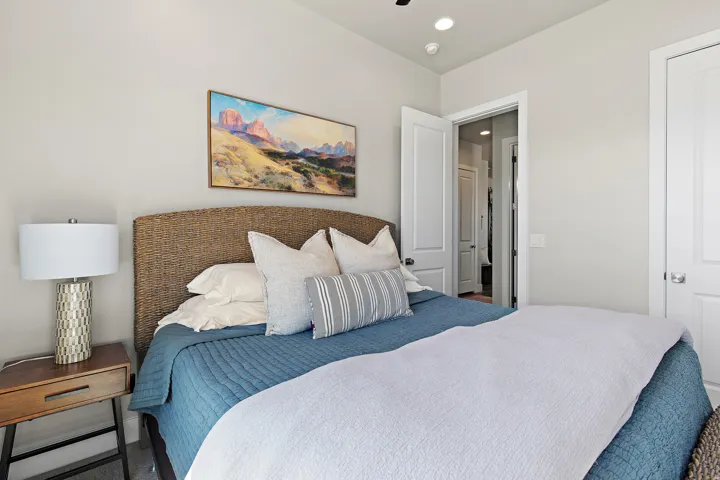 Weave-patterned headboard, recessed ceiling lighting, light-colored wall paint, white interior doors