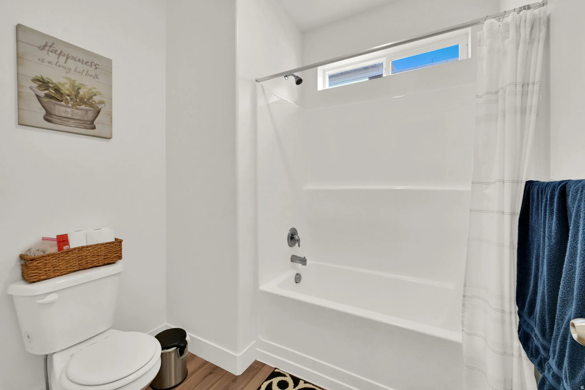Bathtub with integrated shower, chrome fixtures, and a high transom window