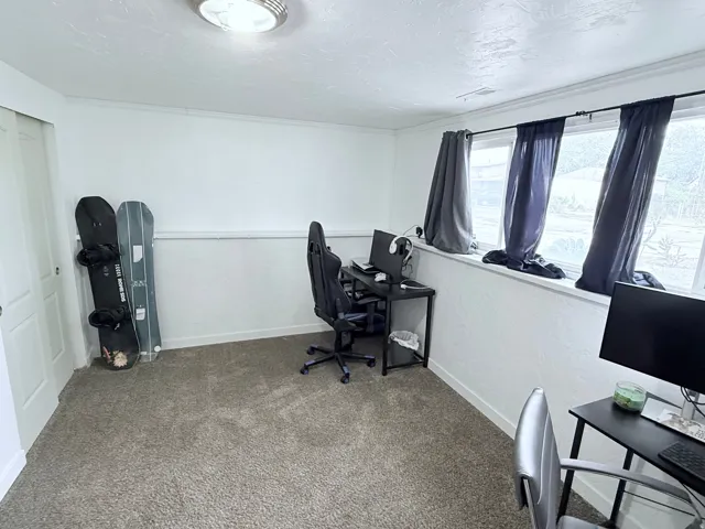 Recessed lighting, white walls, carpeted flooring, and a multi-pane window with a deep sill