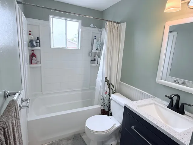 Bathroom featuring a built-in tub/shower combination, white subway tile surround, and a window