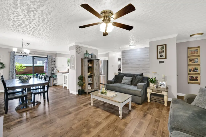 Open-concept living area with wood-finish flooring, a contemporary ceiling fan, and recessed lighting