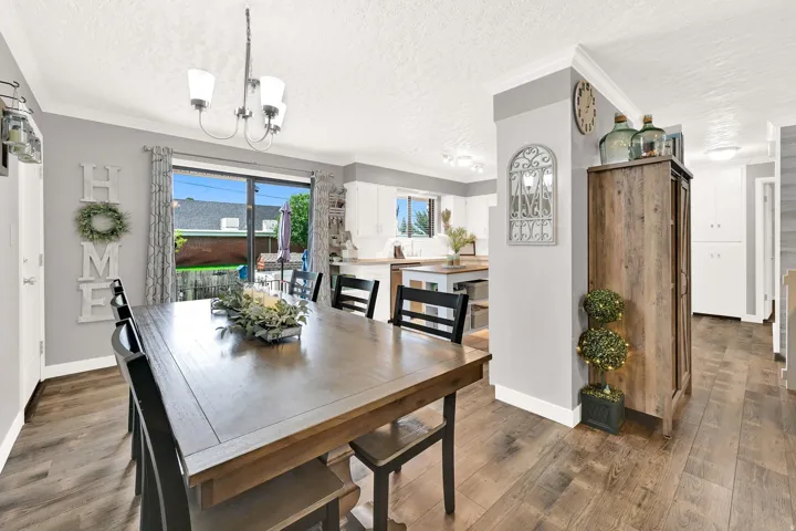 Wood-finish flooring, recessed lighting, crown molding, and sliding glass door