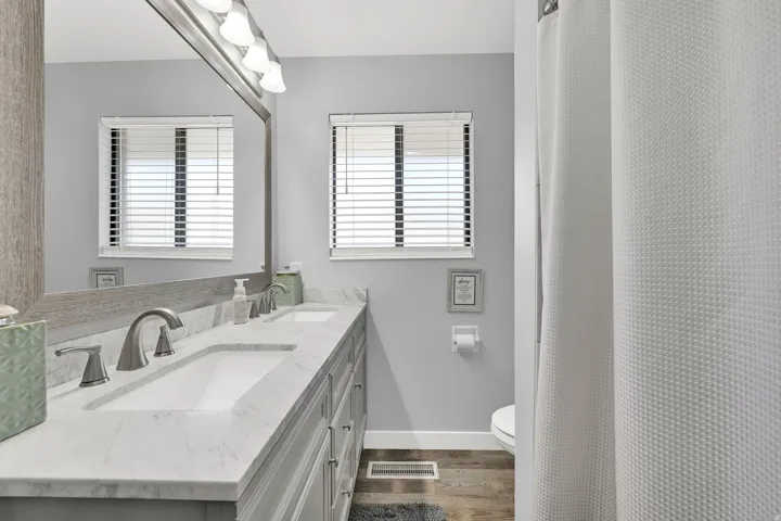 Dual vanity with integrated sinks, brushed nickel fixtures, and a light-toned countertop