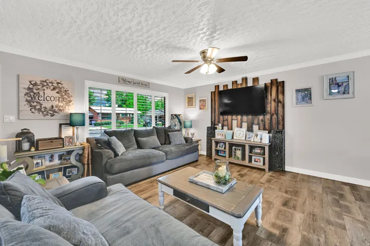 Wood-finish flooring, ceiling fan, and wall-mounted wooden feature