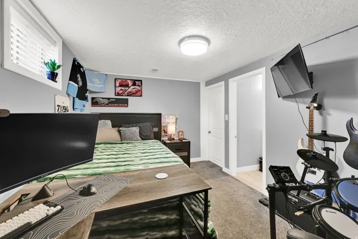 Carpeted room featuring a window with blinds, a built-in ceiling light, and two white panel doors
