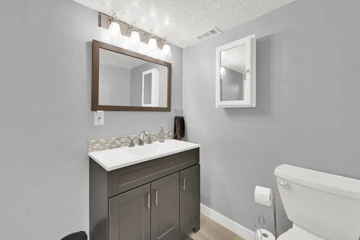 Dark-finished vanity with a white countertop and integrated sink