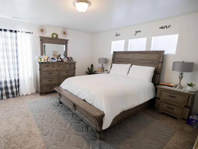 Carpeted flooring, recessed windows, ceiling-mounted light fixture, and white wall finishes