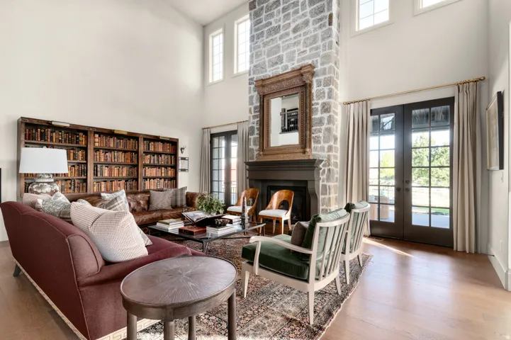 Vaulted ceilings, a full-height stone fireplace, and light wood-finish flooring