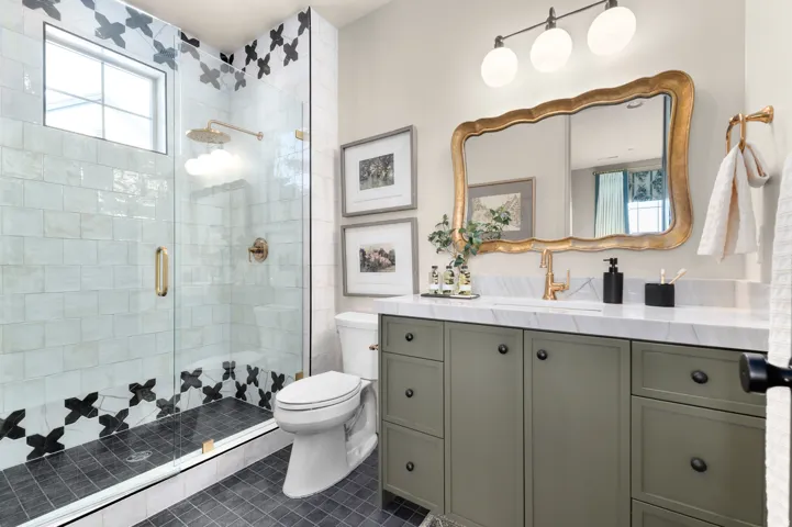 Glass-enclosed shower with decorative tile accents, a built-in shower bench, and a transom window