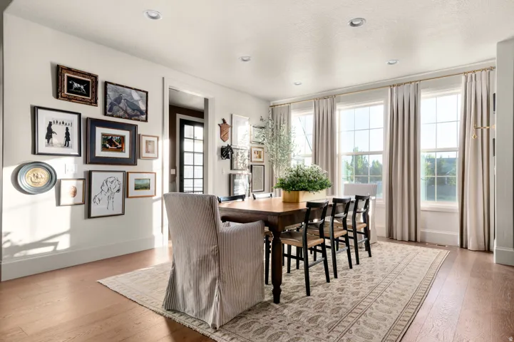 Hardwood flooring, recessed lighting, and a series of three large windows