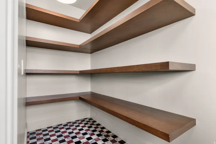 Wood-finish floating shelves with a checkered tile floor