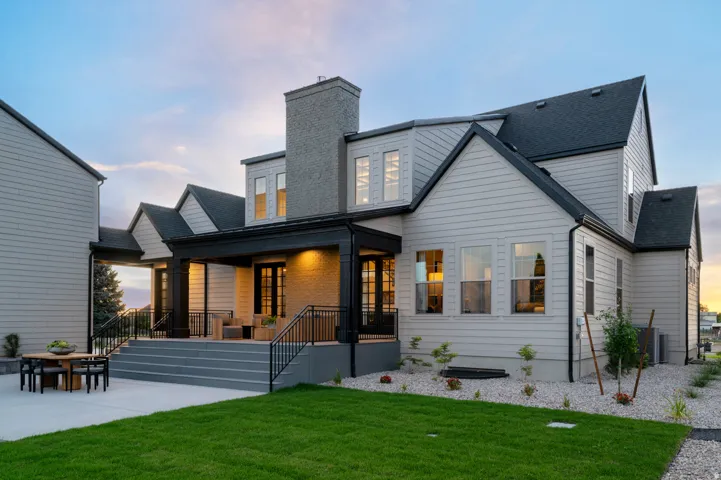Covered outdoor patio with dark trim, black railings, and a concrete patio