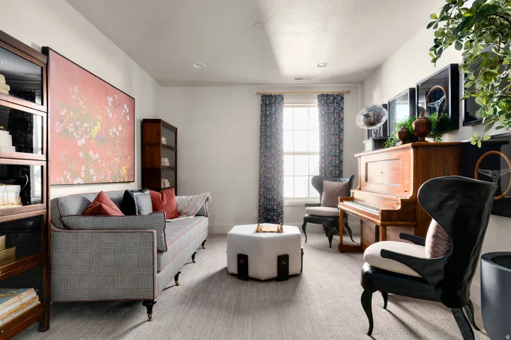 Recessed lighting, light-colored walls, window with patterned drapes, built-in shelving, and carpeted flooring