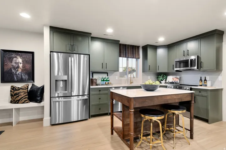 Contemporary kitchen featuring olive green cabinetry, stainless steel appliances, and wood-finish flooring