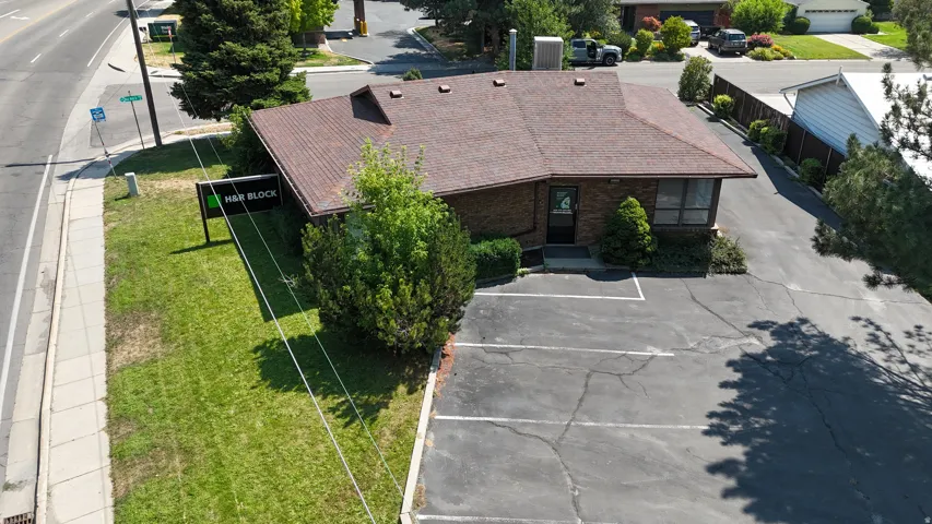 Single-story commercial building with a brown shingle roof, brick exterior, and multiple windows