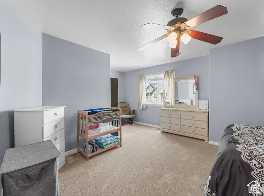 Neutral-toned carpeting, light blue wall paint, and a ceiling fan with integrated lighting