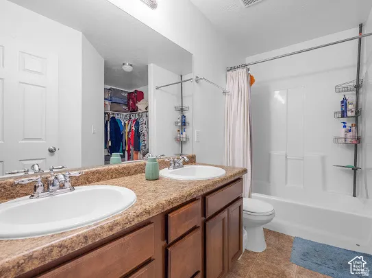 Double vanity with integrated sinks, wood-finish cabinetry, and a full-width mirror
