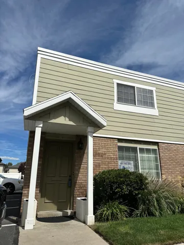Two-story facade featuring brick and horizontal siding