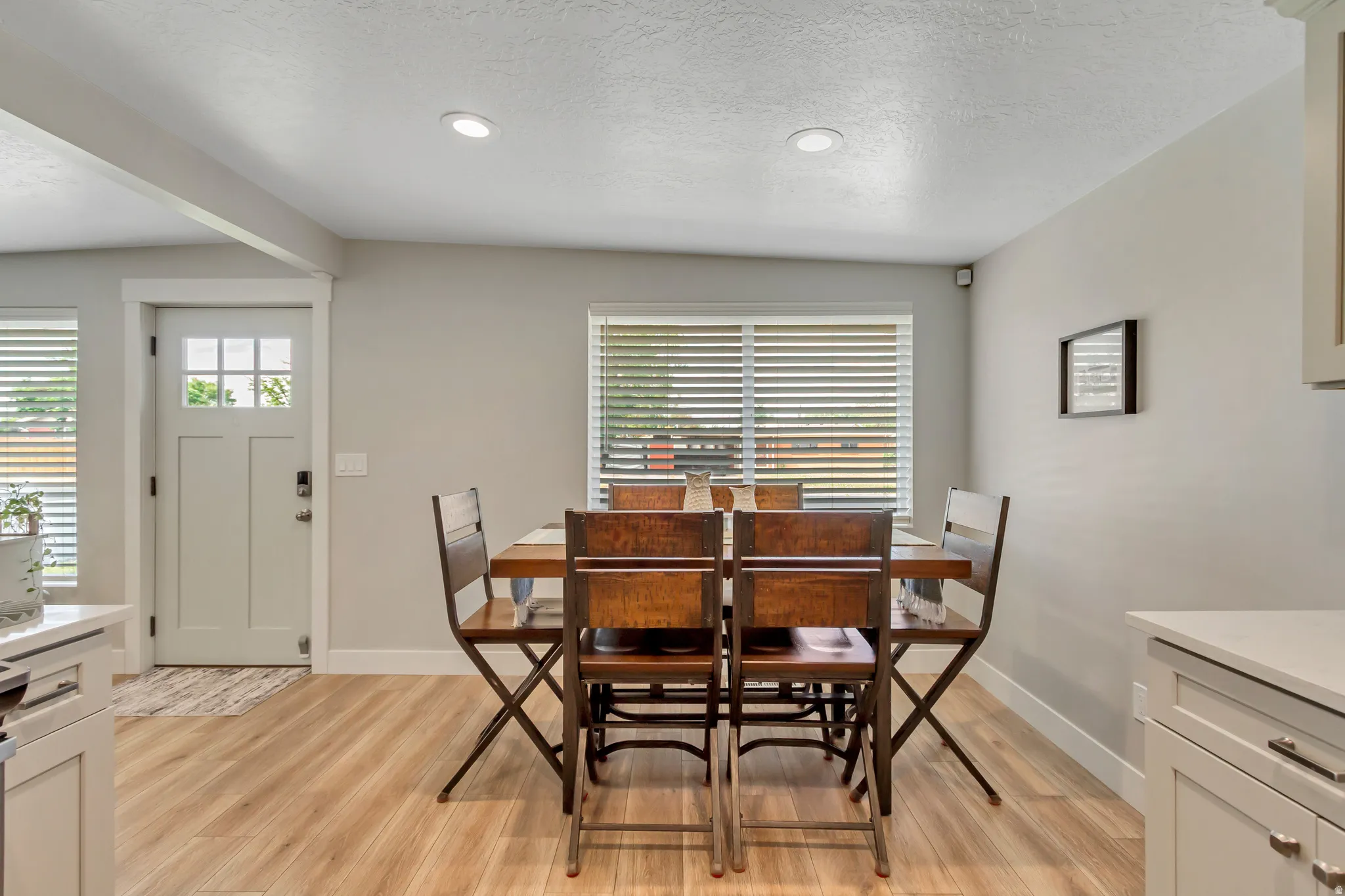 Light wood-finish flooring with recessed lighting and a built-in kitchen cabinet
