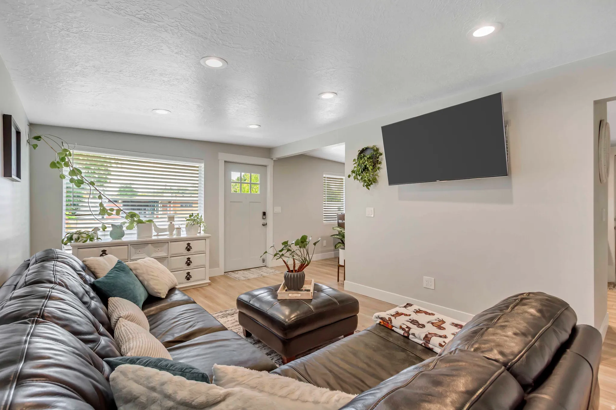 Recessed ceiling lighting, wood-finish flooring, white trim, and a window with blinds