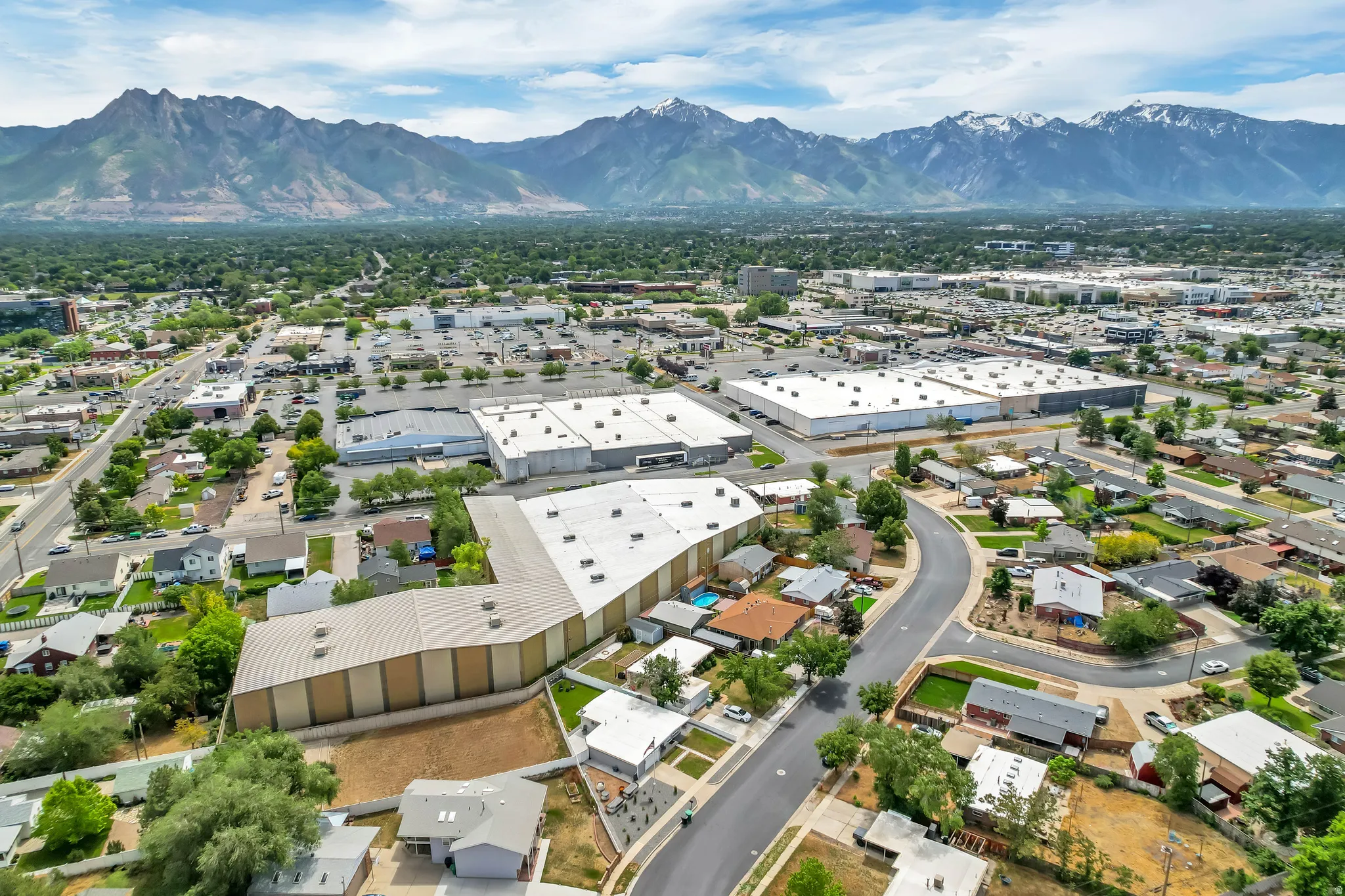 Aerial perspective showcasing residential areas, commercial buildings, and mountainous backdrops