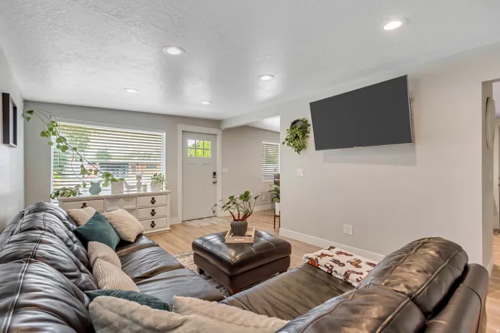 Recessed ceiling lighting, wood-finish flooring, white trim, and a window with blinds