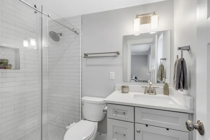 Glass-enclosed shower with subway tile surround and built-in niche