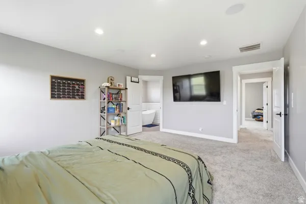 Recessed ceiling lighting, light gray wall paint, white trim, gray carpet, and white paneled interior doors