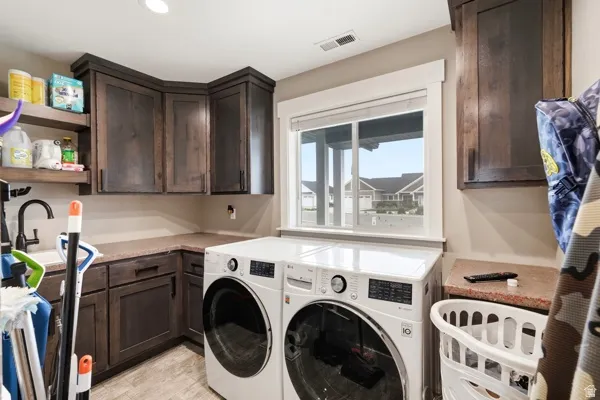 Dark wood-finish cabinetry, built-in shelving, undermount sink with a matte black faucet, and light-toned countertops